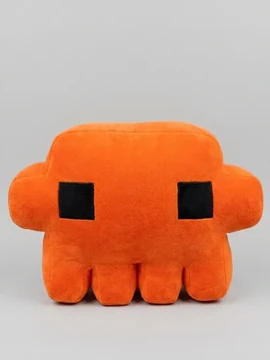 A product-style photograph of an orange Claude plush with square black eyes against a pale gray background.